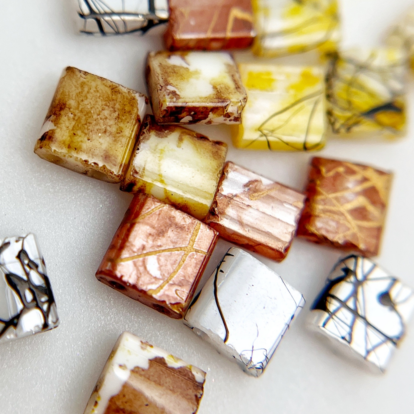 Multicolor square resin nail charms on white background.