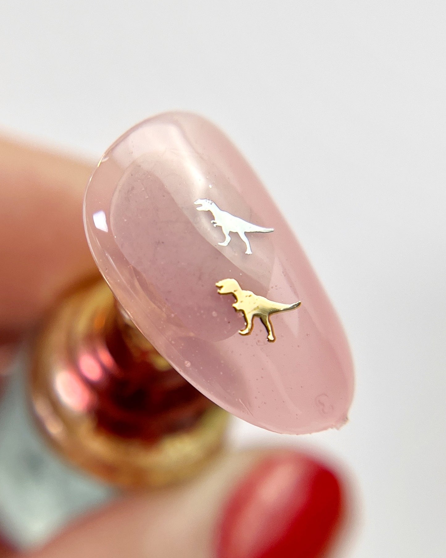 Hand holding decorated nail tip.