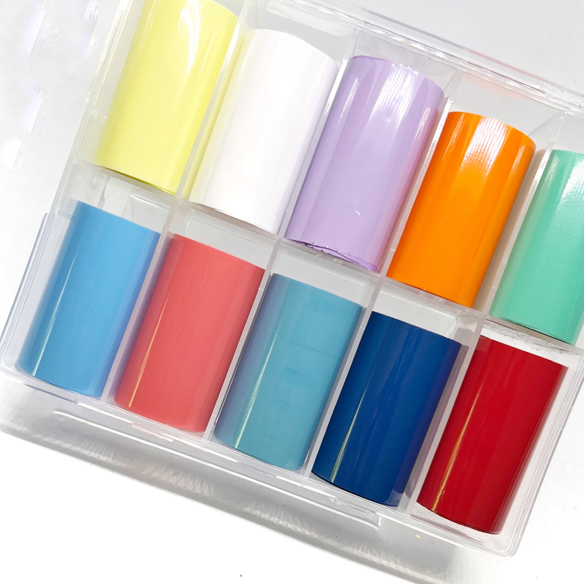 Solid Gloss Foil Set - 10 Solid Glossy (Non-Metallic) Foils in Pale Yellow, White, Lavender, Orange, Turquoise, Light Blue, Slate Blue, Pink, Dark Blue, and Red, Presented in a Clear Case on a White Background.