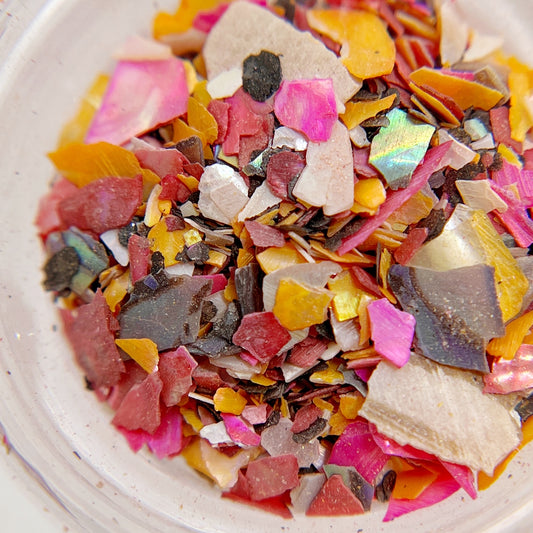Detail shot of multicolor shell mix in clear jar on white background. 