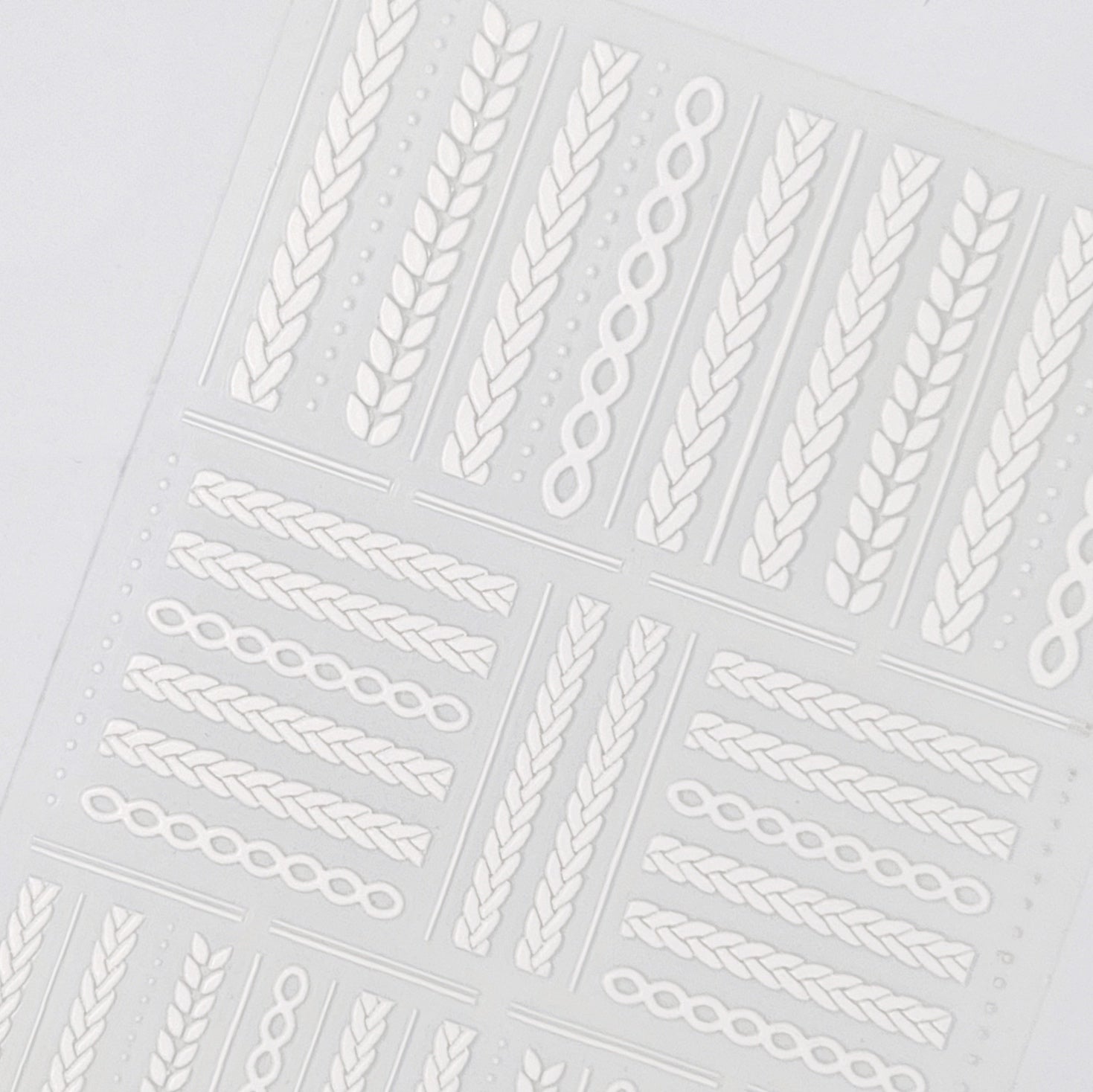 Detailed view of embossed texture white braided stickers. 