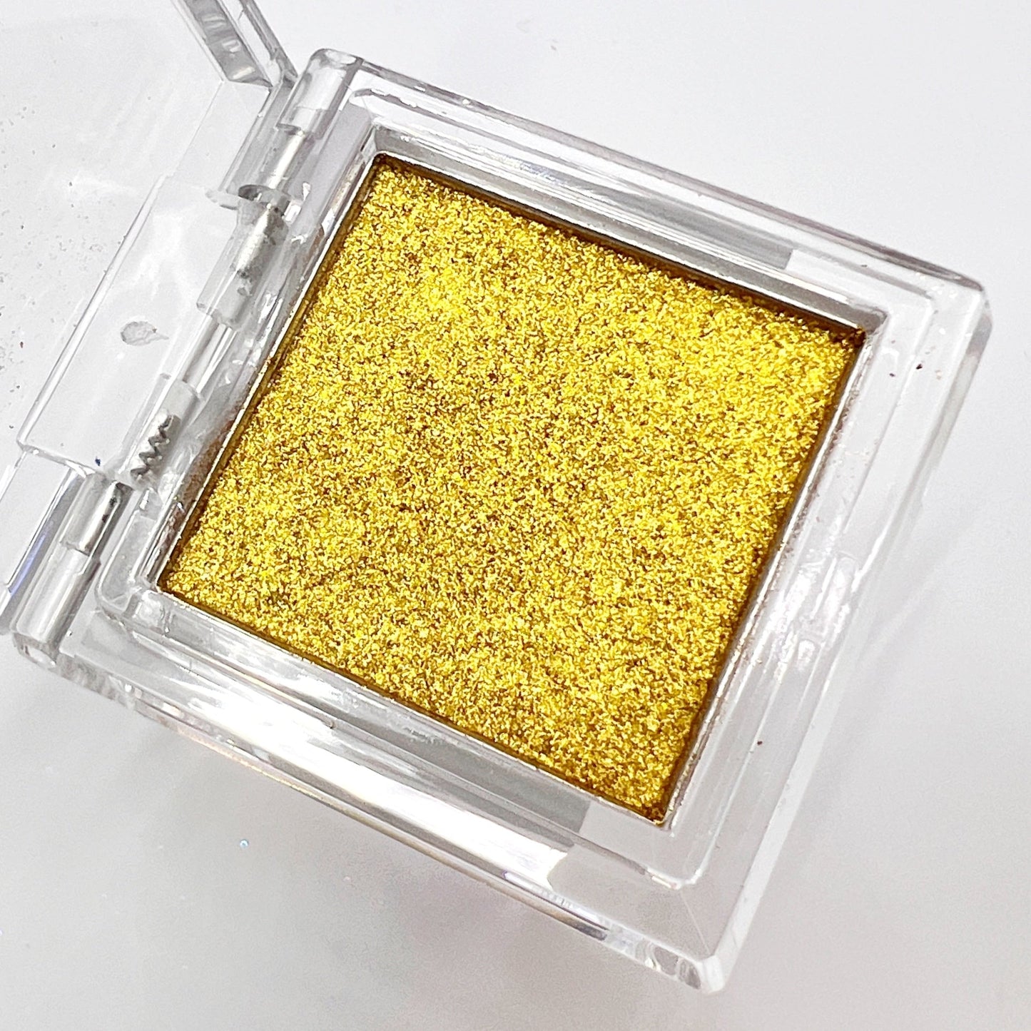 Detail view of  compact with metallic powder on white background. 