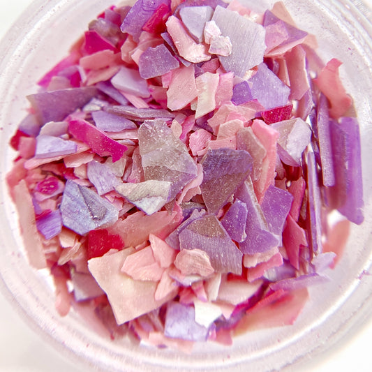 Detail shot of multicolor shell mix in clear jar on white background.