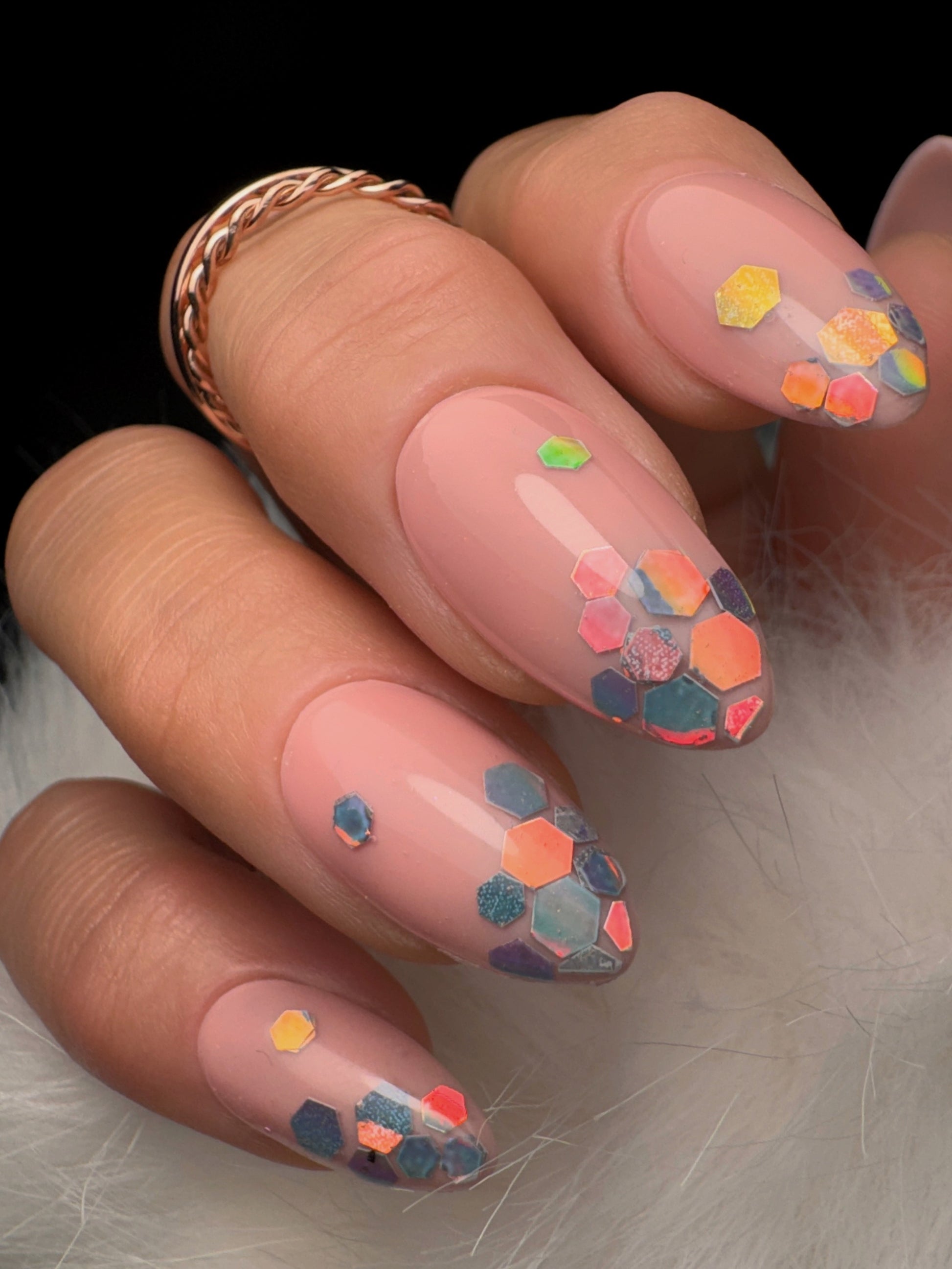 Nail art with colorful geometric patterns on a neutral background