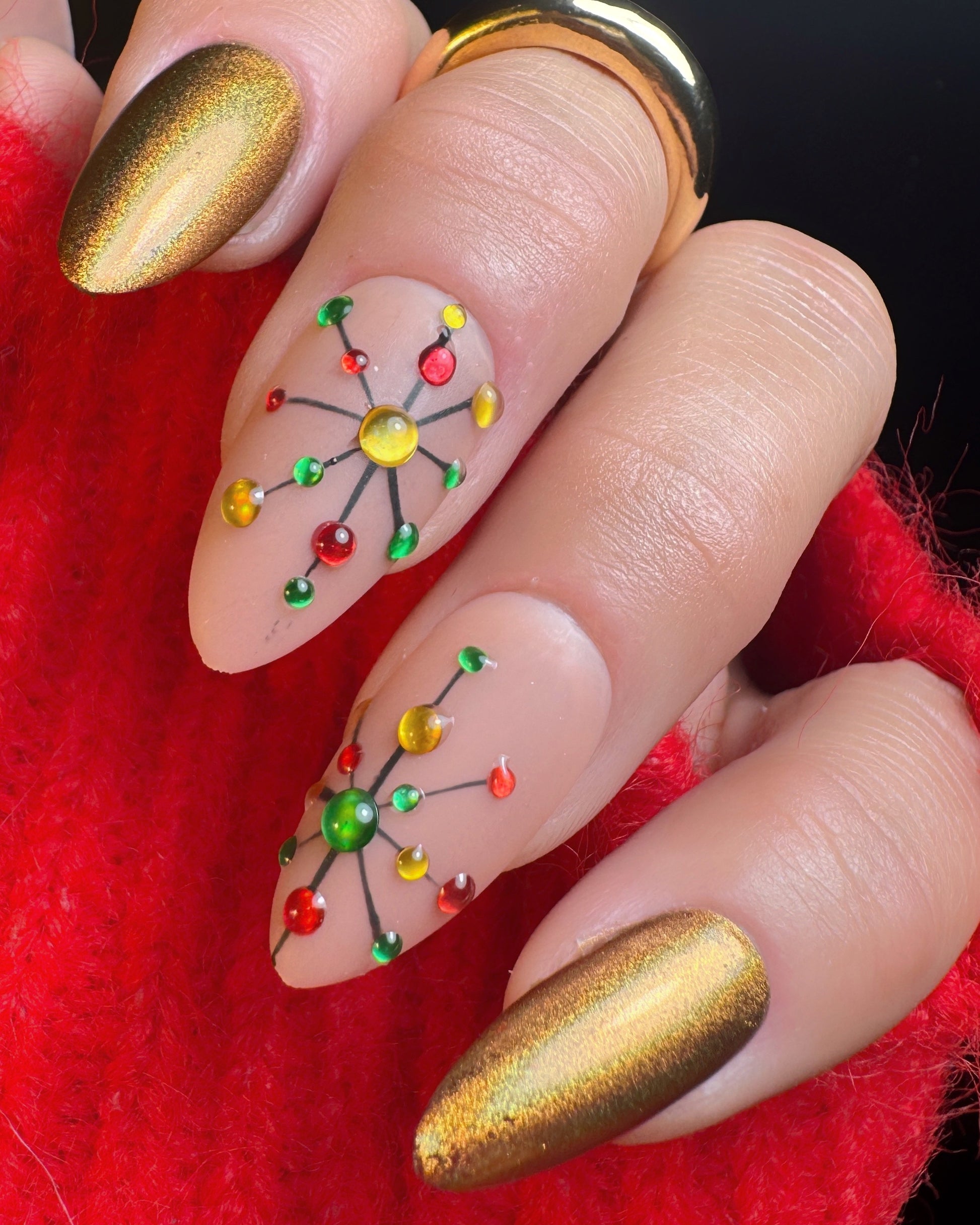 Nail art with colorful design on a red fabric background