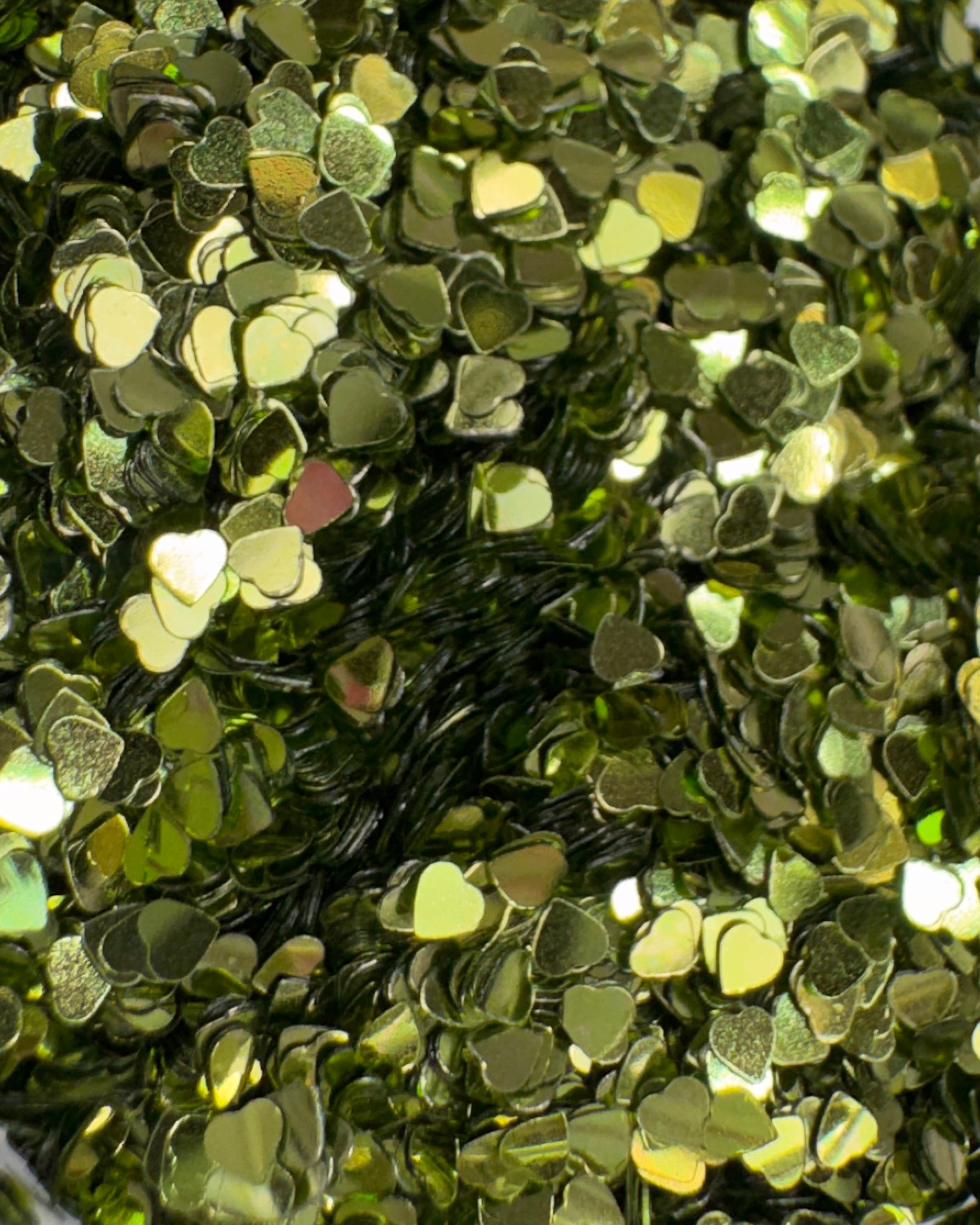 Close-up of green heart-shaped sequins on a black background