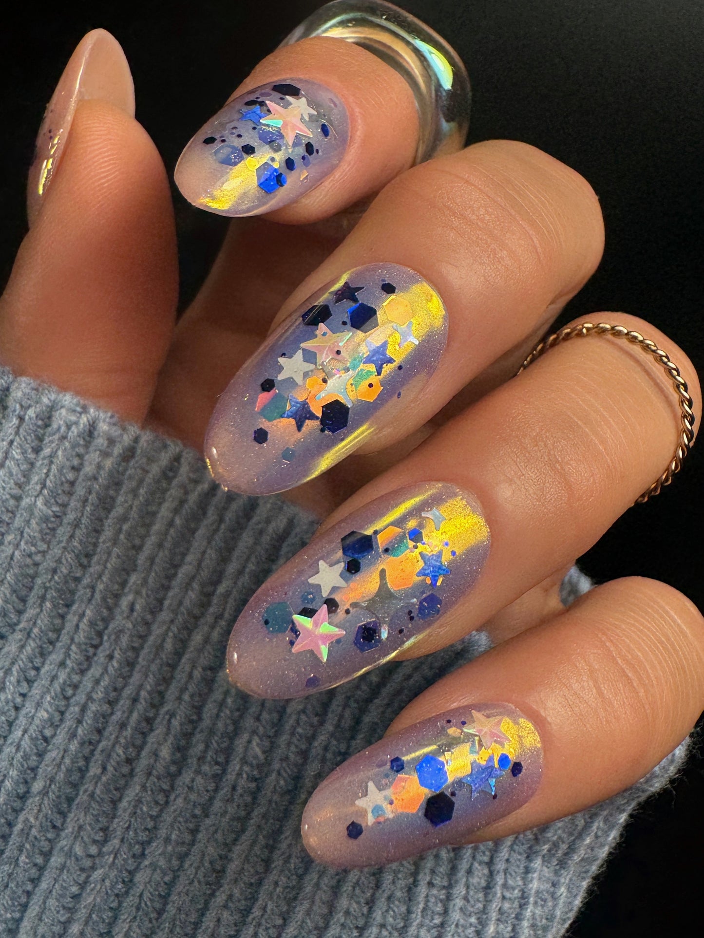 Nails with colorful star and dot design on a dark background