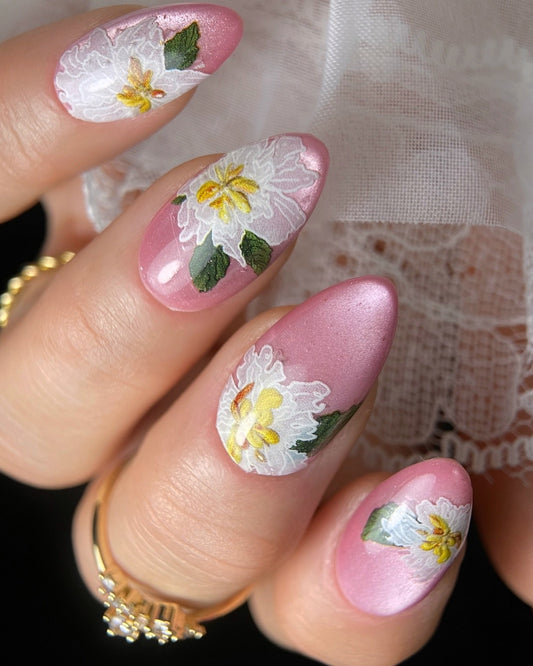 Close-up of hand with good ring, lace cuff and floral nail art. 