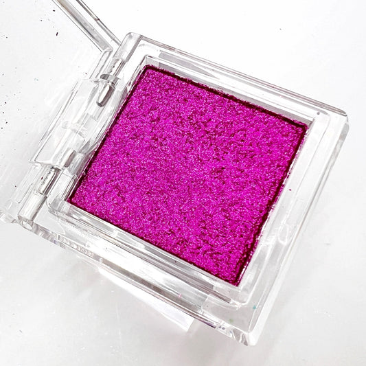 Detail view of  compact with metallic powder on white background. 