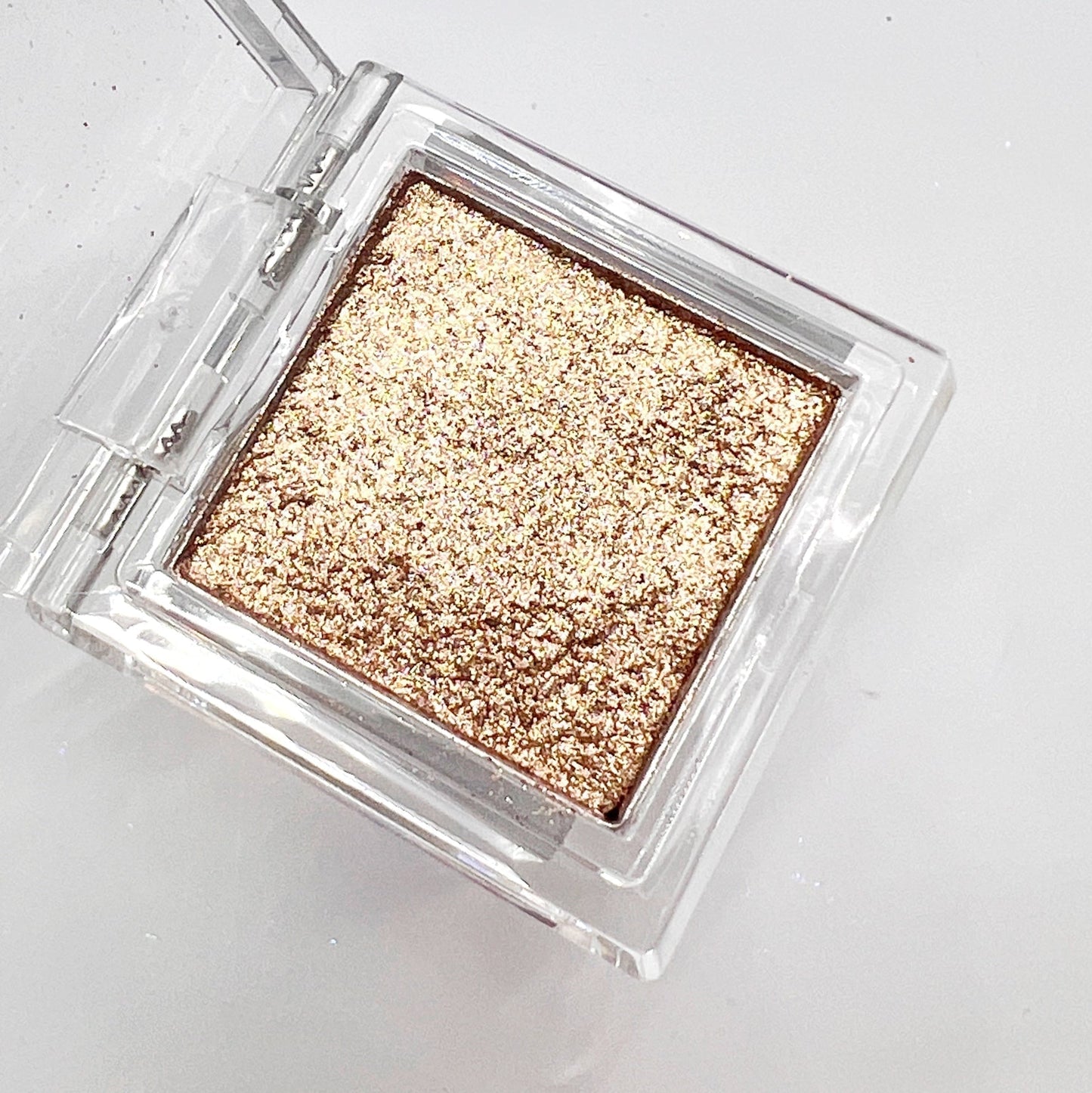 Detail view of  compact with metallic powder on white background. 