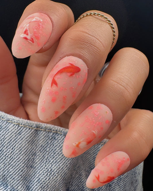 Nails with fish design and pink base color