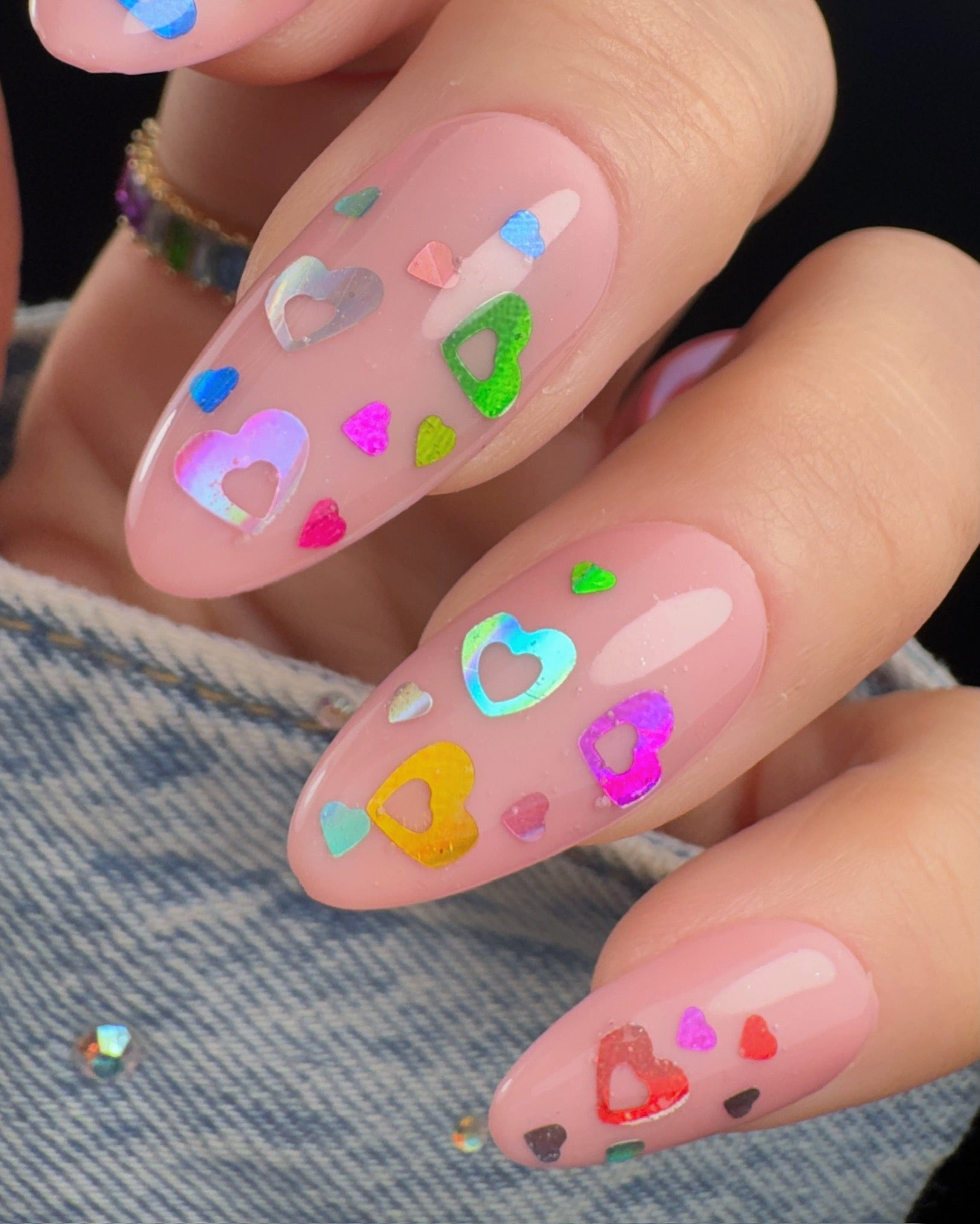 Nails with colorful heart designs on a denim background