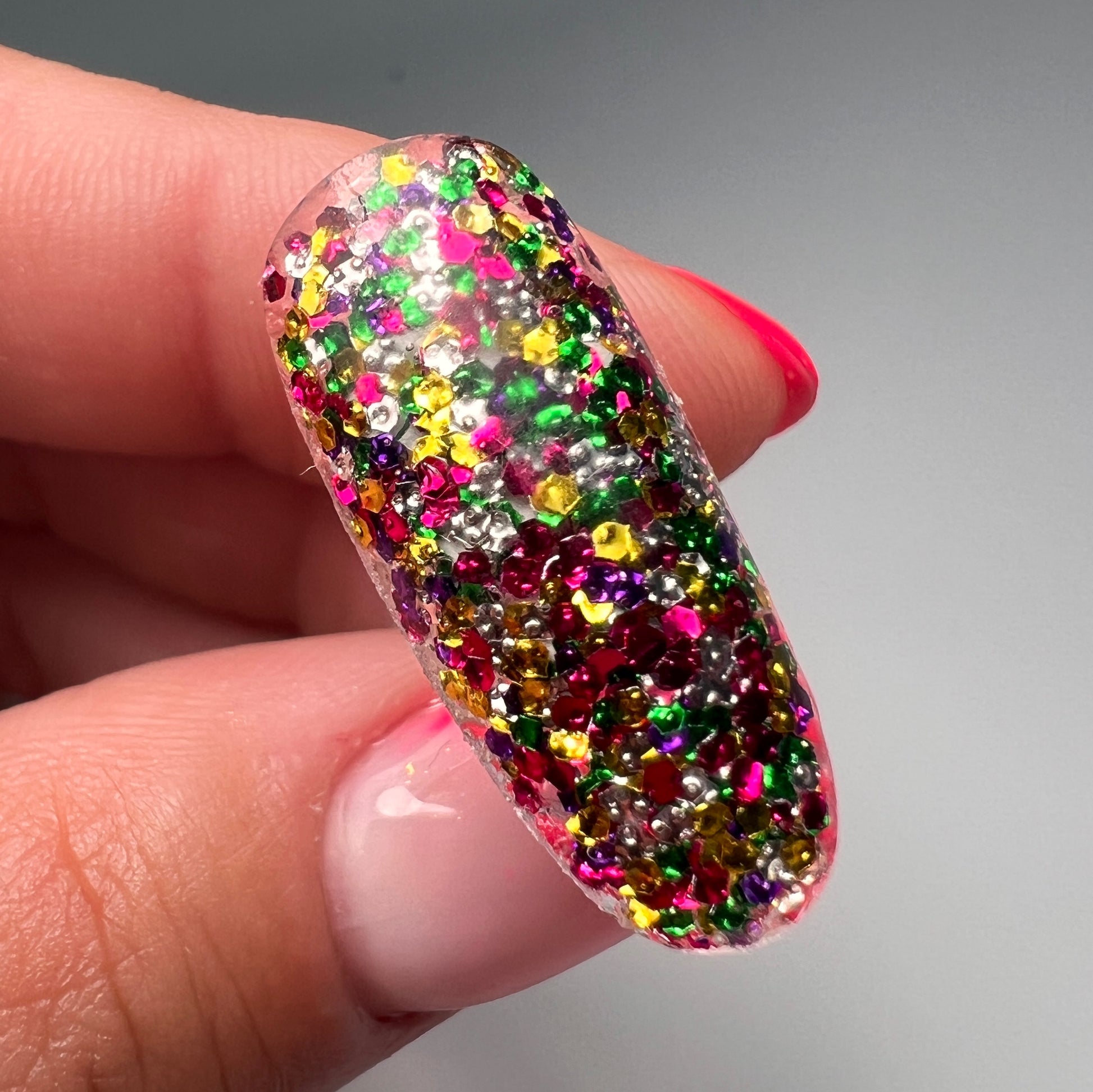 Hand holding decorated nail art tip. 