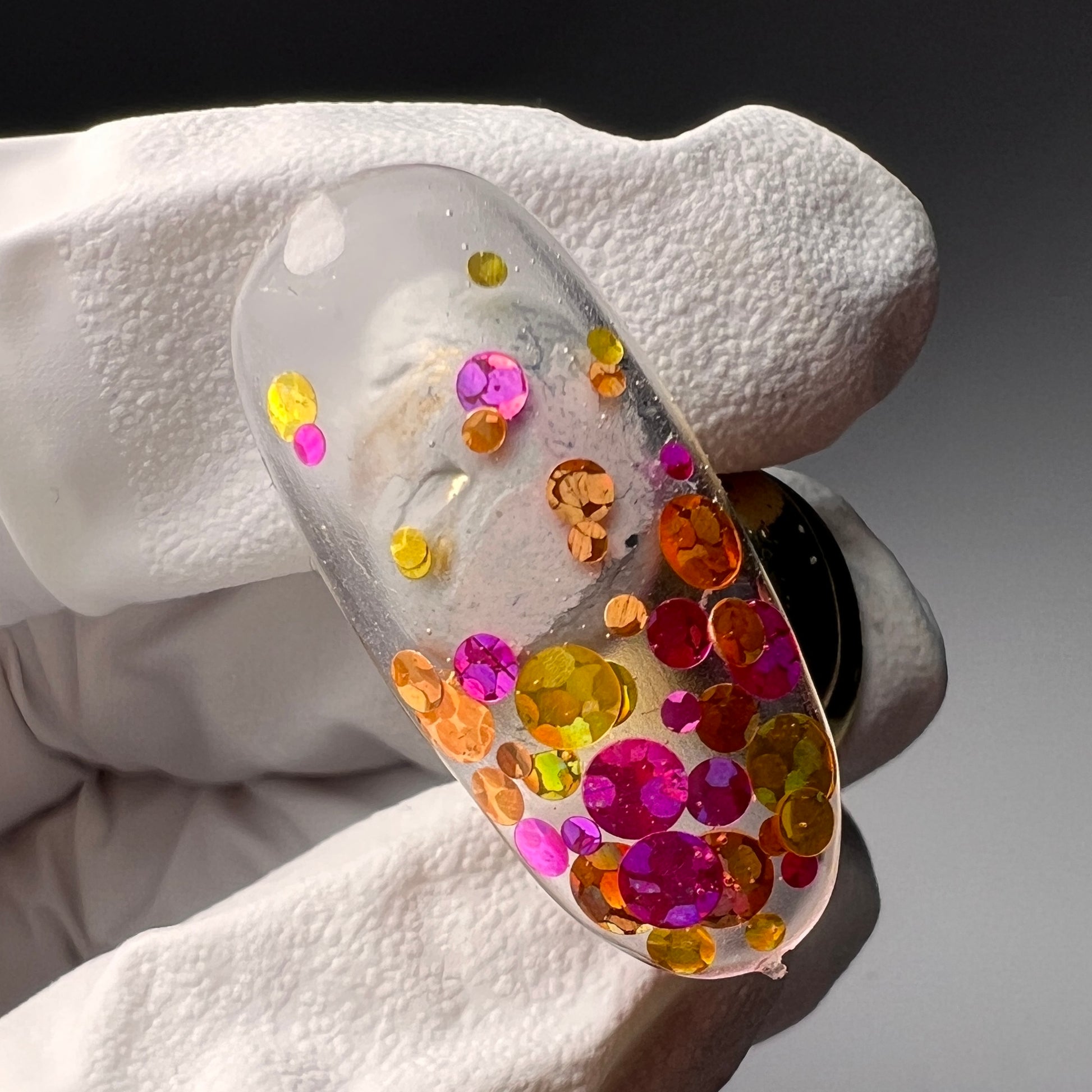 Hand holding decorated nail tip.