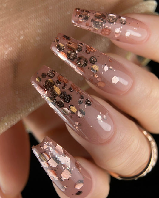 Nails with rose gold glitter design on a neutral background