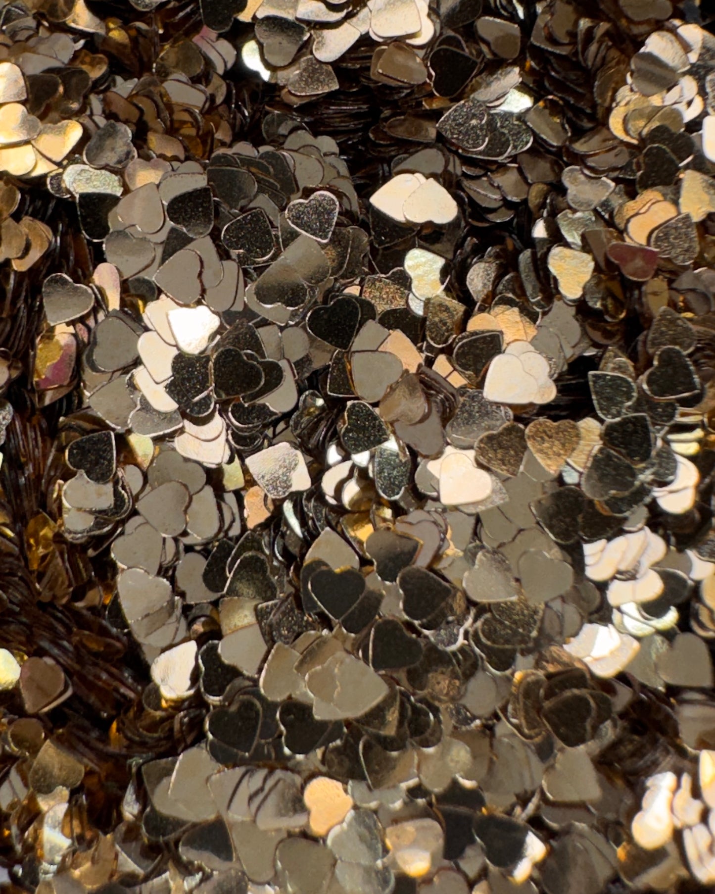 Close-up of metallic heart-shaped gitter in gold shade.