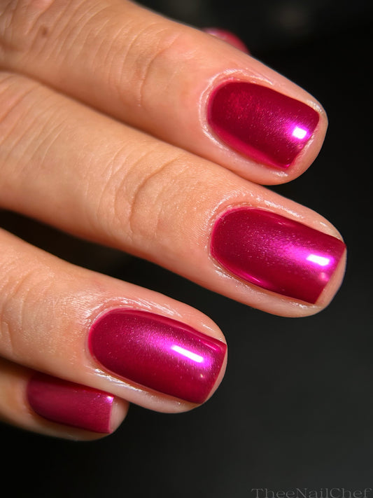 Close-up of glossy hot pink chrome nails by Jennie Guthrie using Vacation Nail Shop Cyber Pink Chrome, shown on short natural nails.