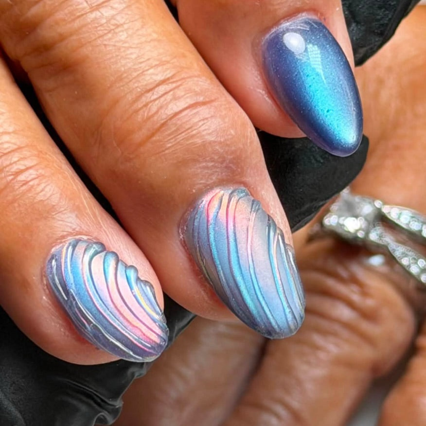 Blue and pink chrome nail art by Renee Abu Ghaben using Vacation Nail Shop Lazer Pink Chrome, with dimensional curved linework creating a sculpted, rippled effect.
