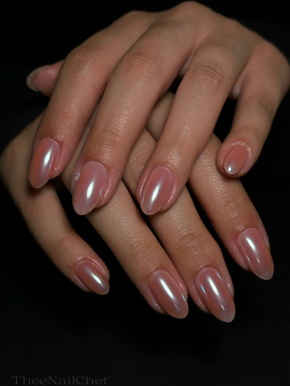 Sheer nude pink manicure by Jennie Guthrie using Vacation Nail Shop Malibu Pearl Chrome, with a subtle pearlescent blue-white glow on natural almond nails.