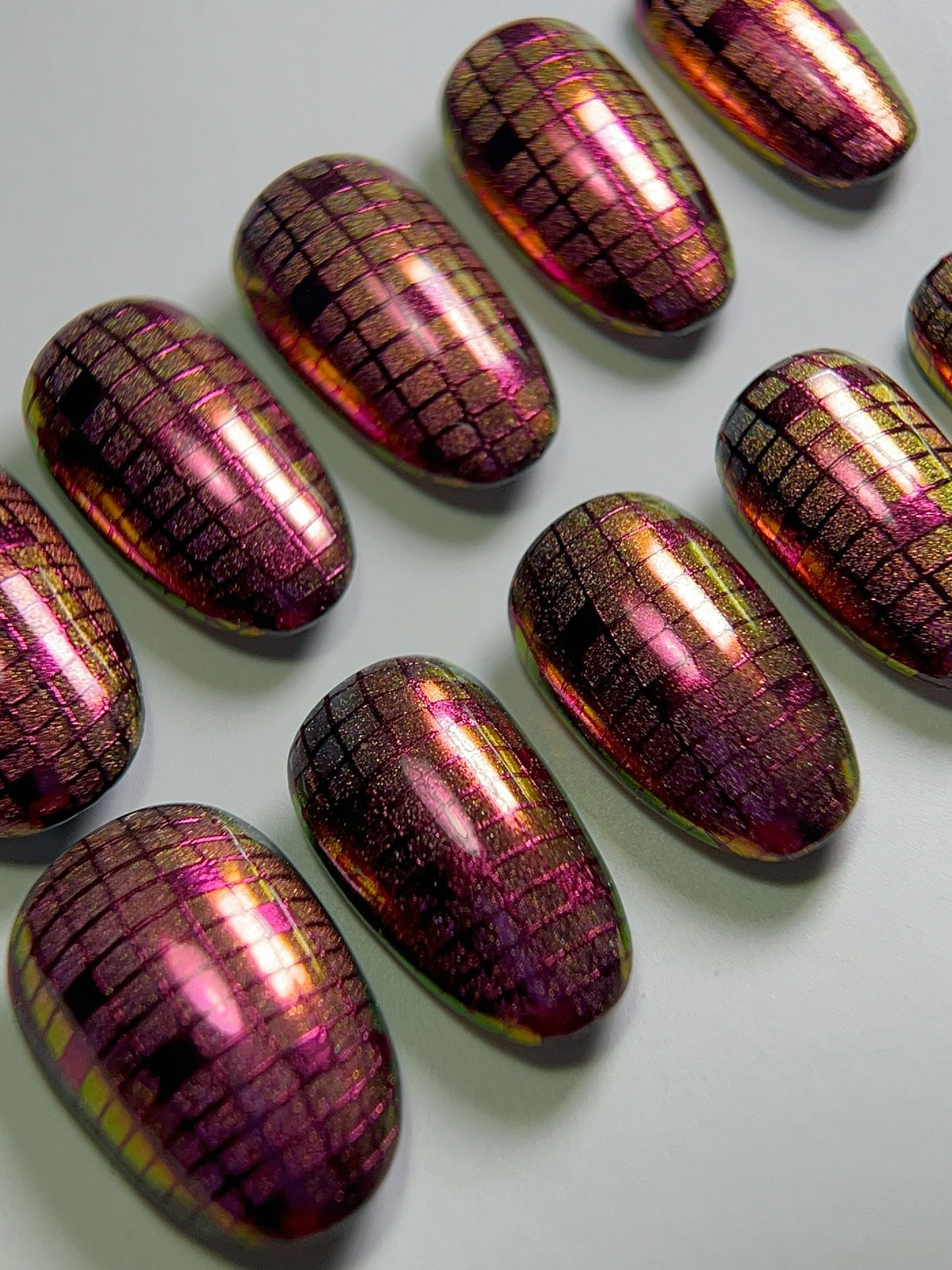 Holographic manicure by Jennie Guthrie with a deep wine berry checkerboard pattern created using Vacation Nail Shop Mulberry Chrome.