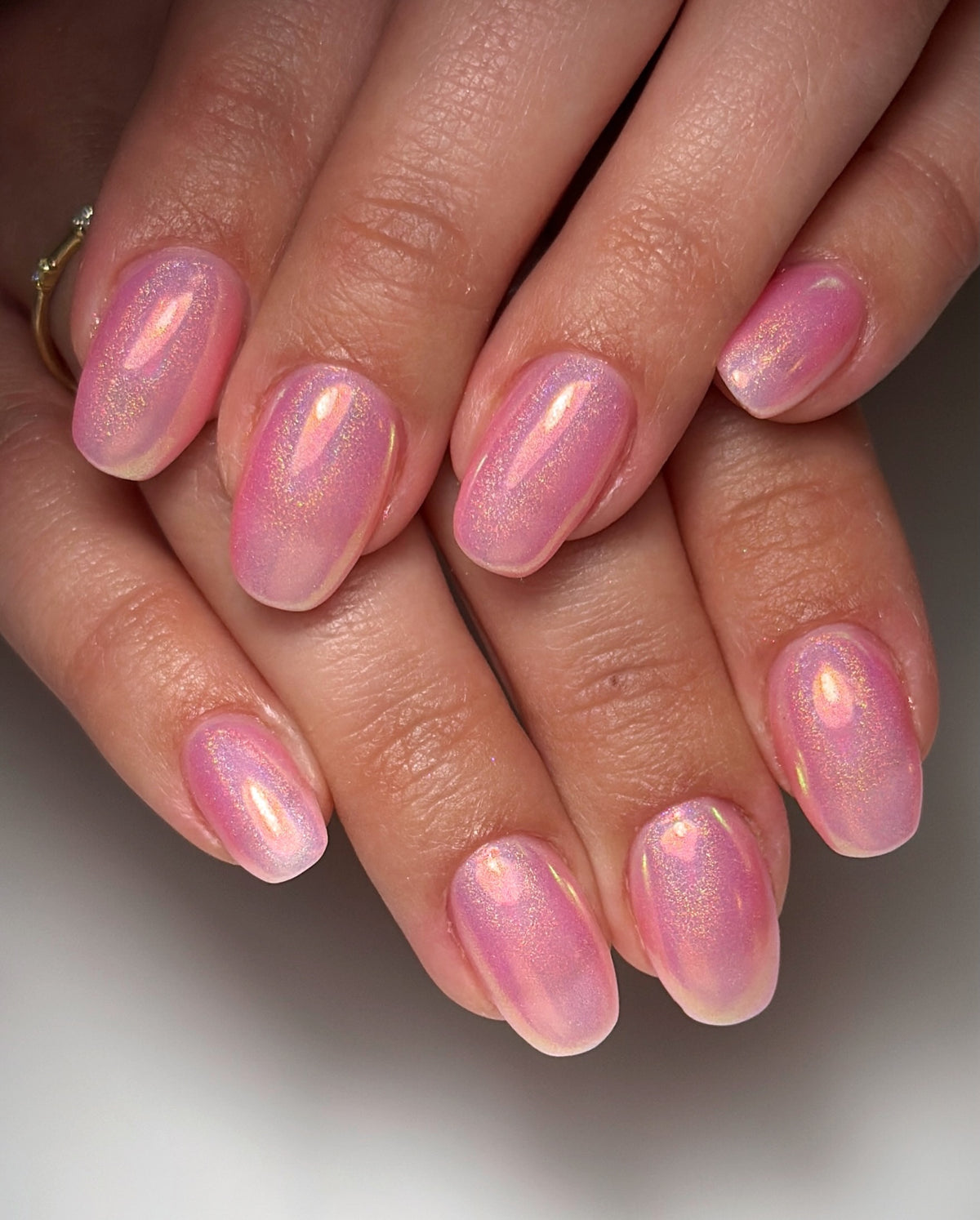 Sheer pink opal chrome manicure by Marissa Asprer using Vacation Nail Shop Opaline Chrome, with a luminous pink and gold iridescent shift on short natural nails.