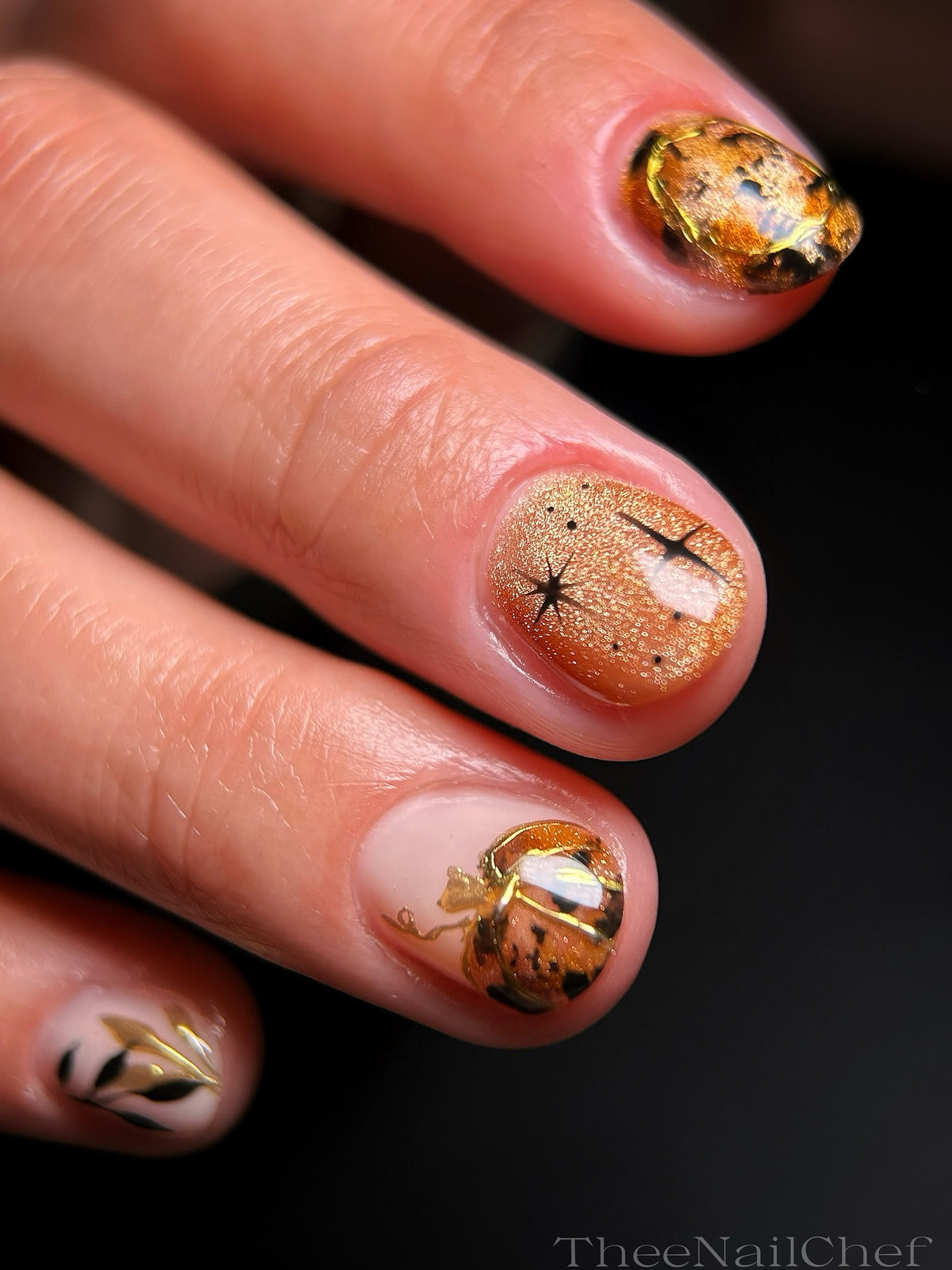 Autumn nail art by Jennie Guthrie using the Vacation Nail Shop Precious Metal Chrome Palette, featuring warm metallic gold and bronze details with dimensional pumpkin-inspired designs.