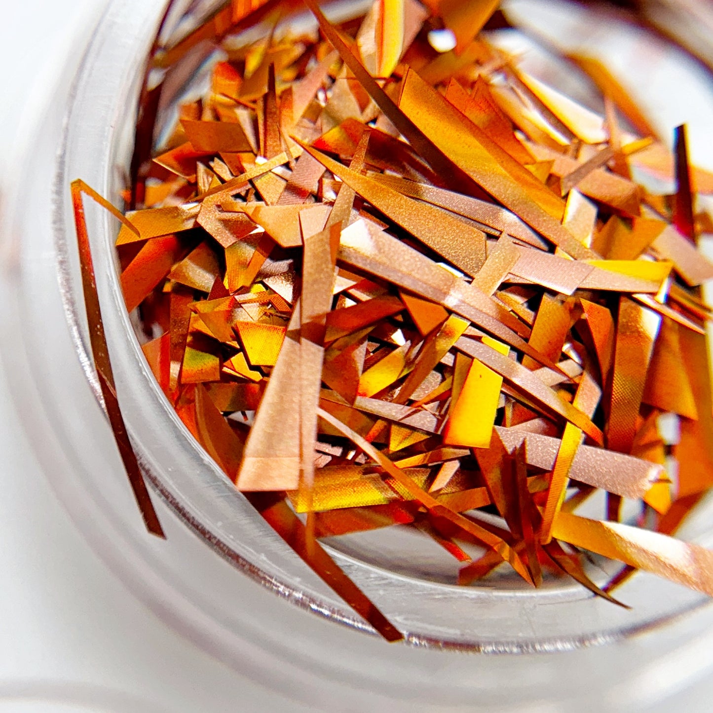 Close-up of iridescent sliced mylar in a transparent container