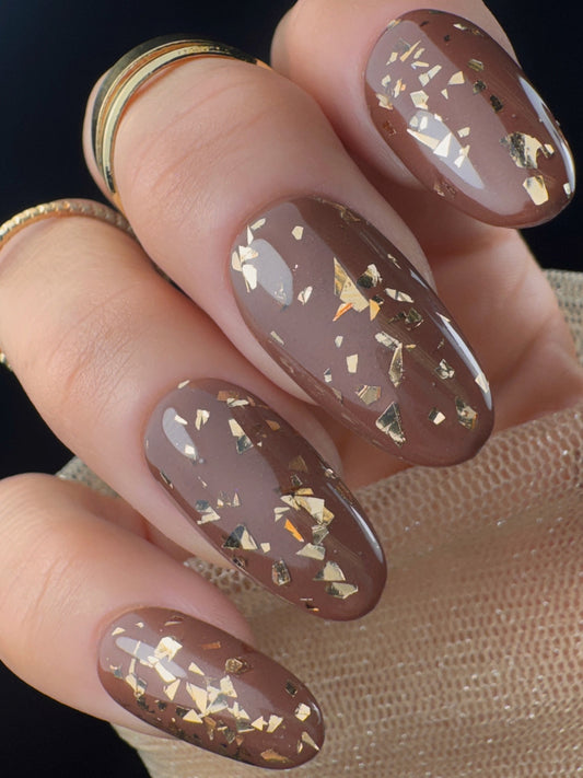 Nails with gold glitter on a neutral background