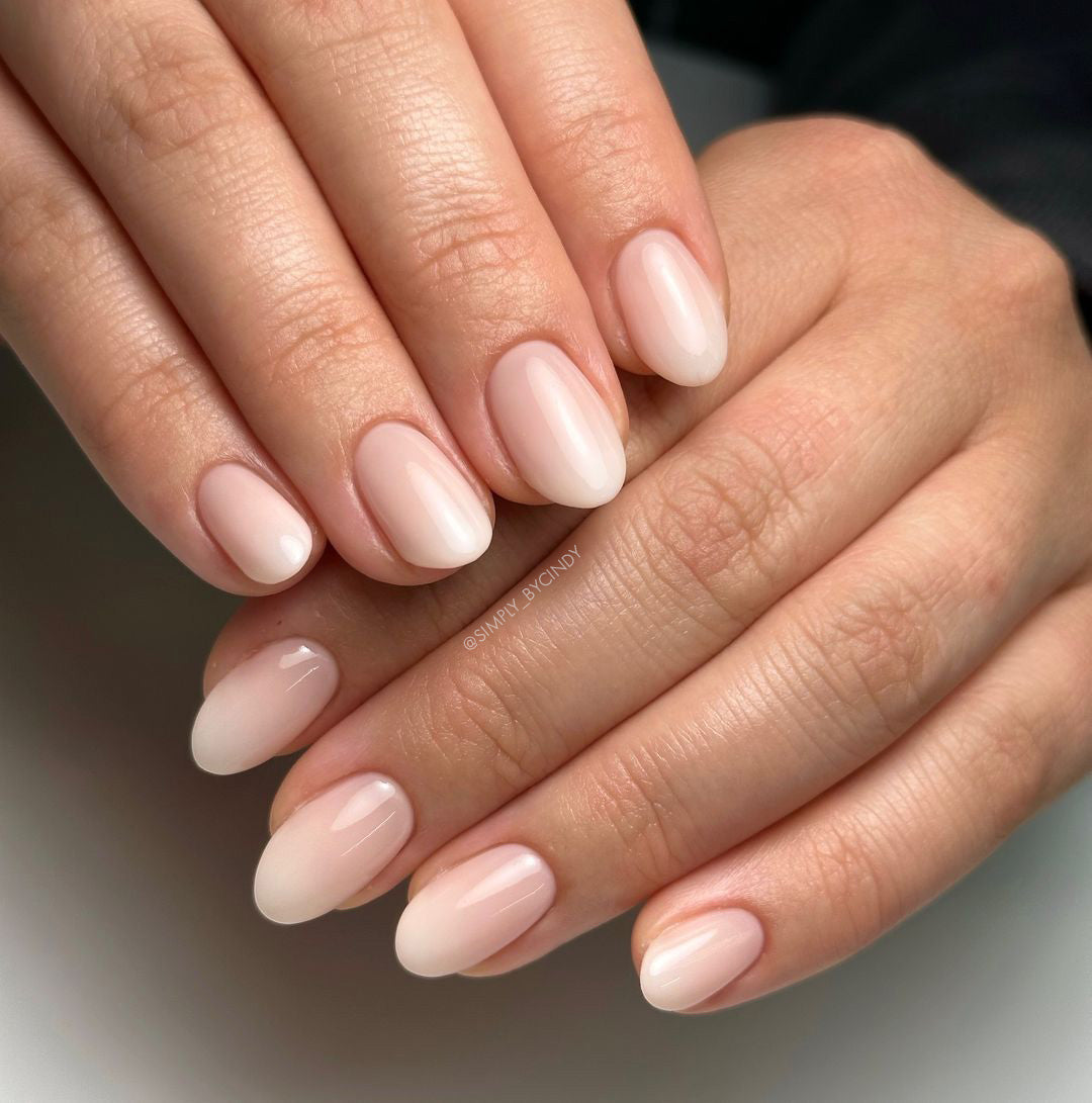 Hands with gradient nail design on light background