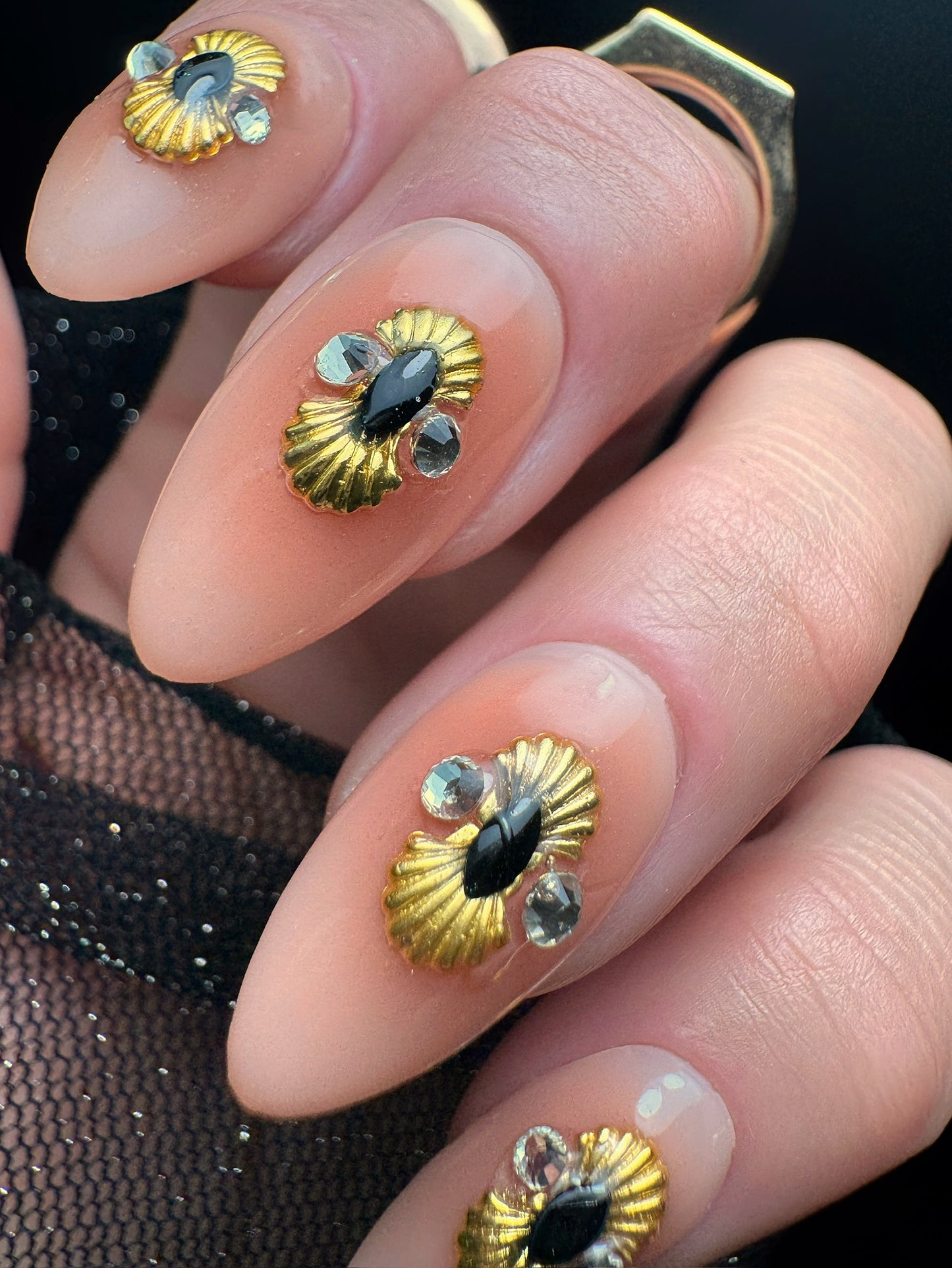Nails with gold and black decorative elements on a dark background