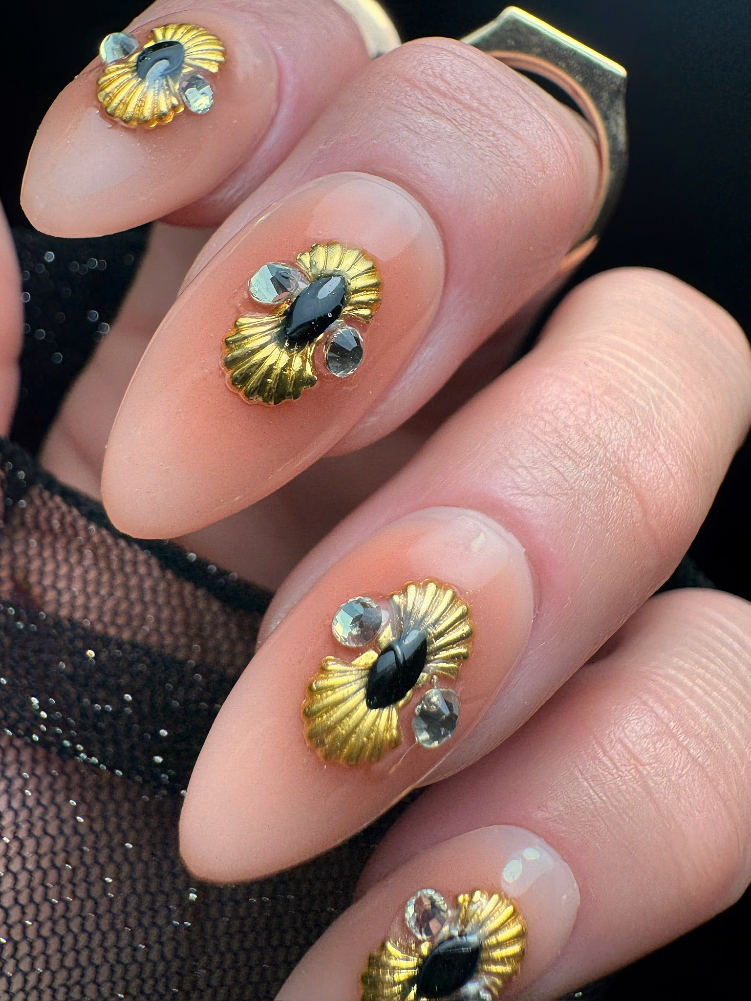 Nails with gold and black decorative elements on a dark background