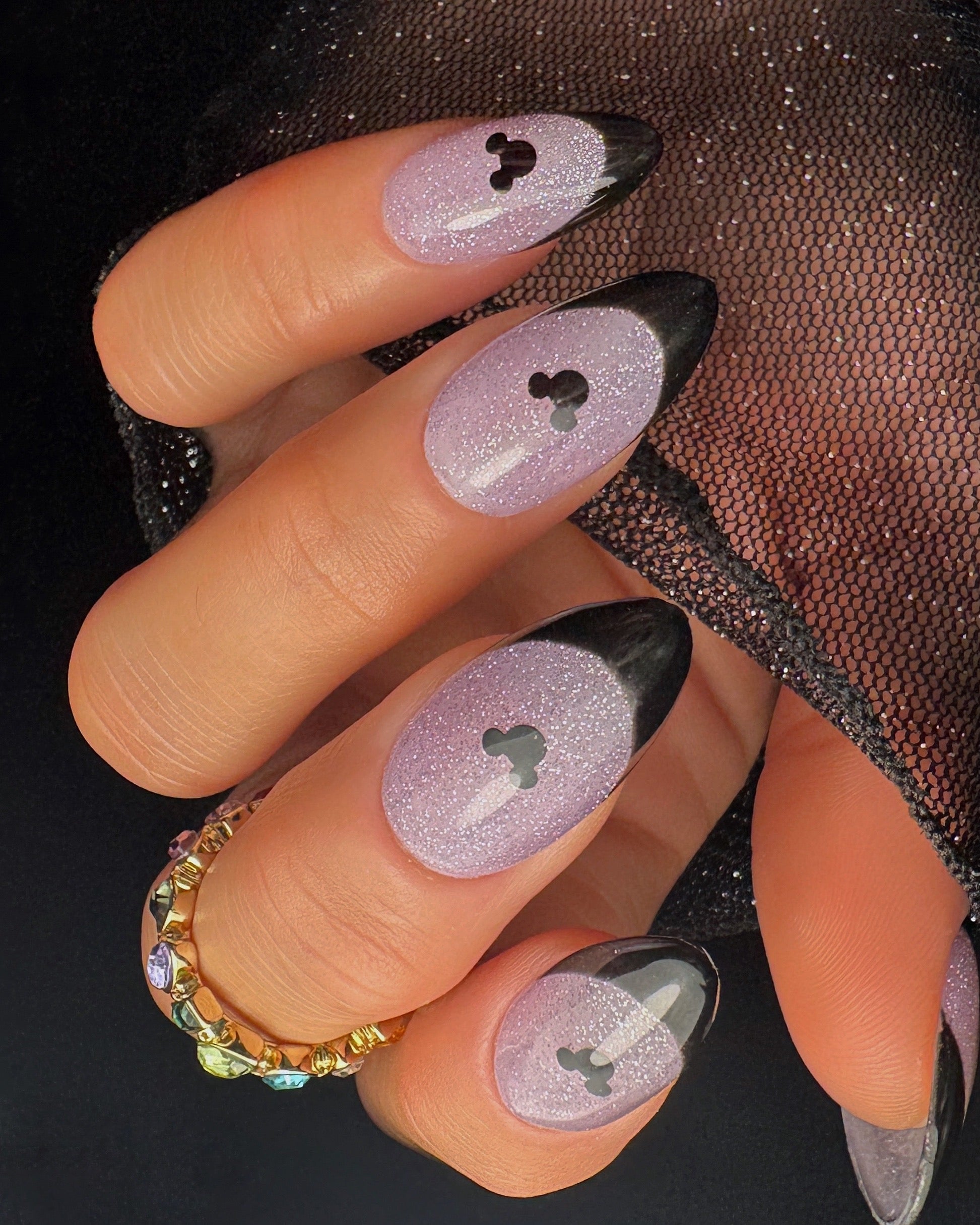 Nail art with a mouse design on a dark background