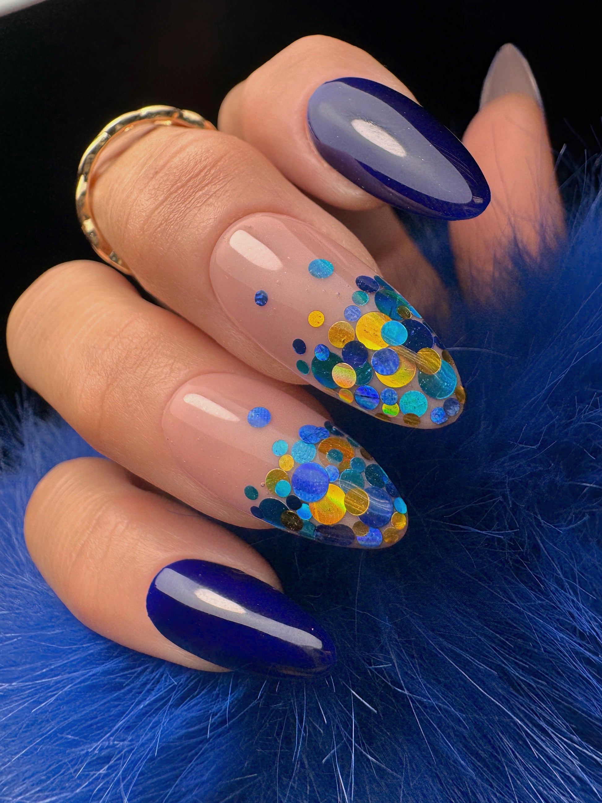Nail art with blue and multicolored dots on a blue fur background