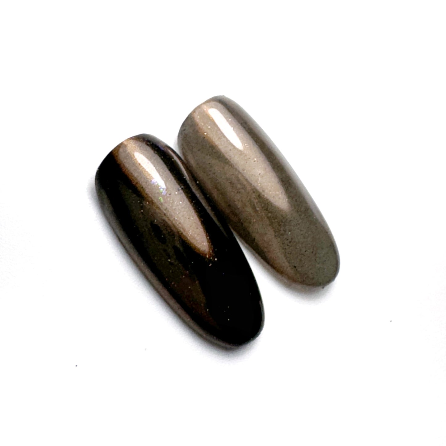 Nail tips with iridescent finish on white surface,