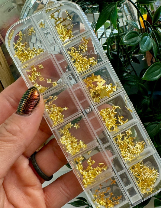 Clear container with gold embellishments held by a hand against a green plant background