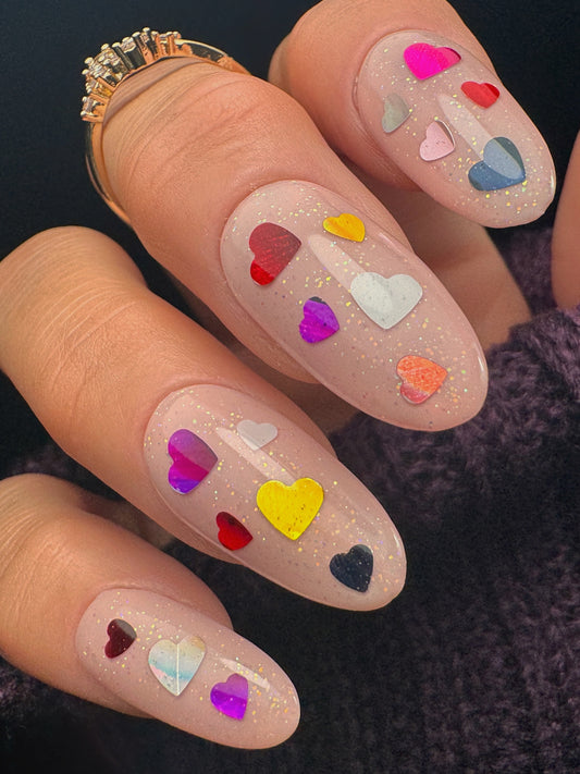 Nails with colorful heart designs on a dark background