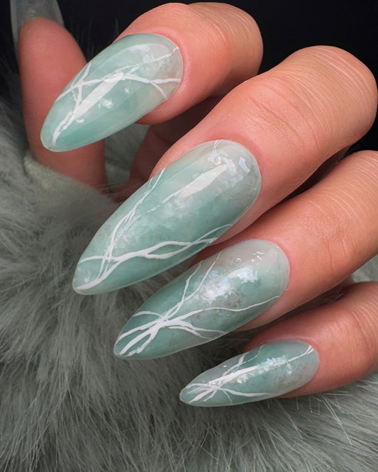 Nails with a light green design on a light  gray background