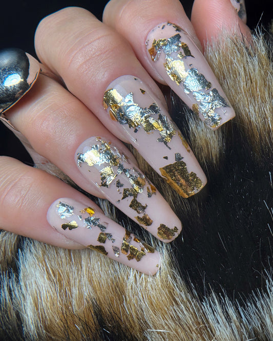 Nails with gold and silver foil design on a fur background