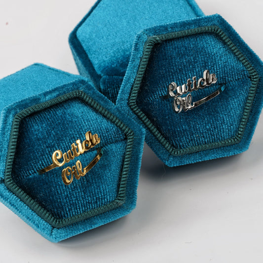 Two blue ringboxes with gold and silver rings staggered on white background. 