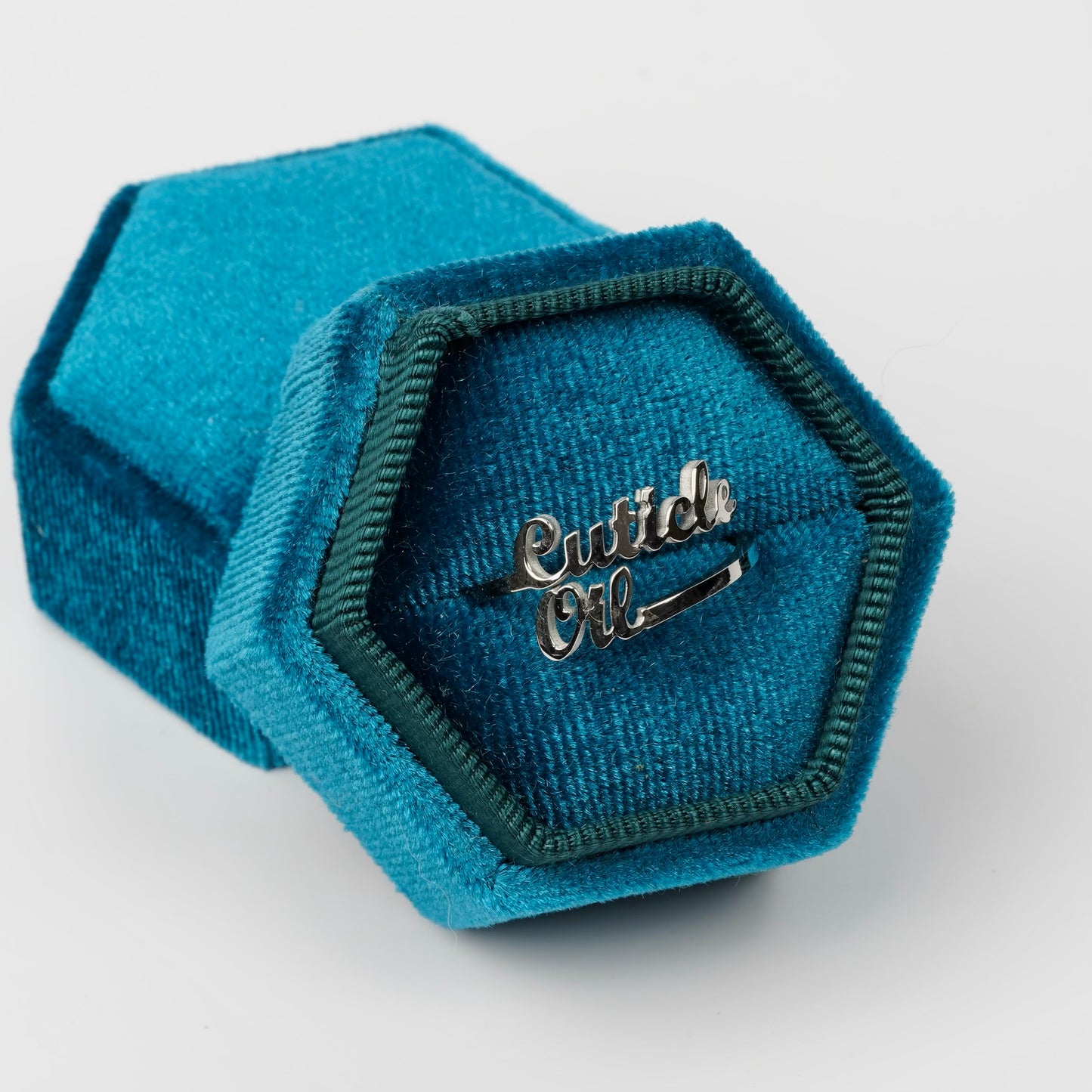 Silver ring in blue ringbox on white background. 