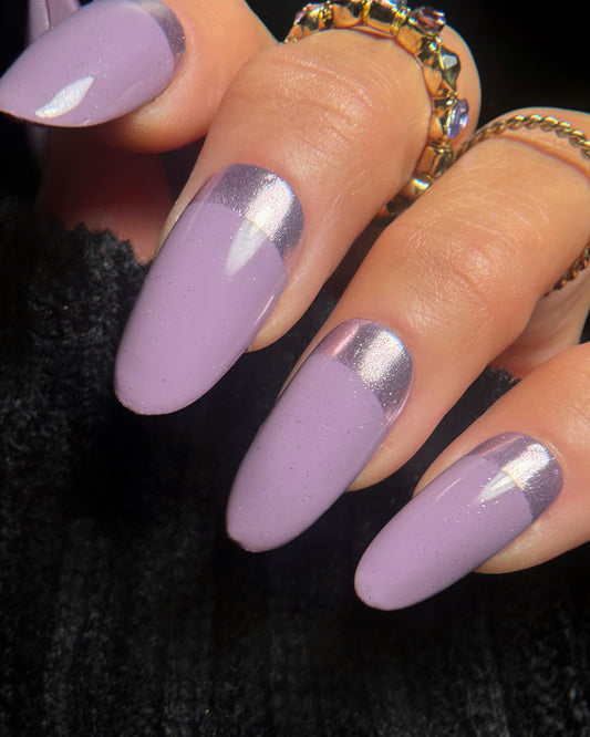 Nails with purple and lilac chrome design on a dark background