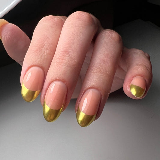 Close-up of a hand with green and nude nail polish on a neutral background