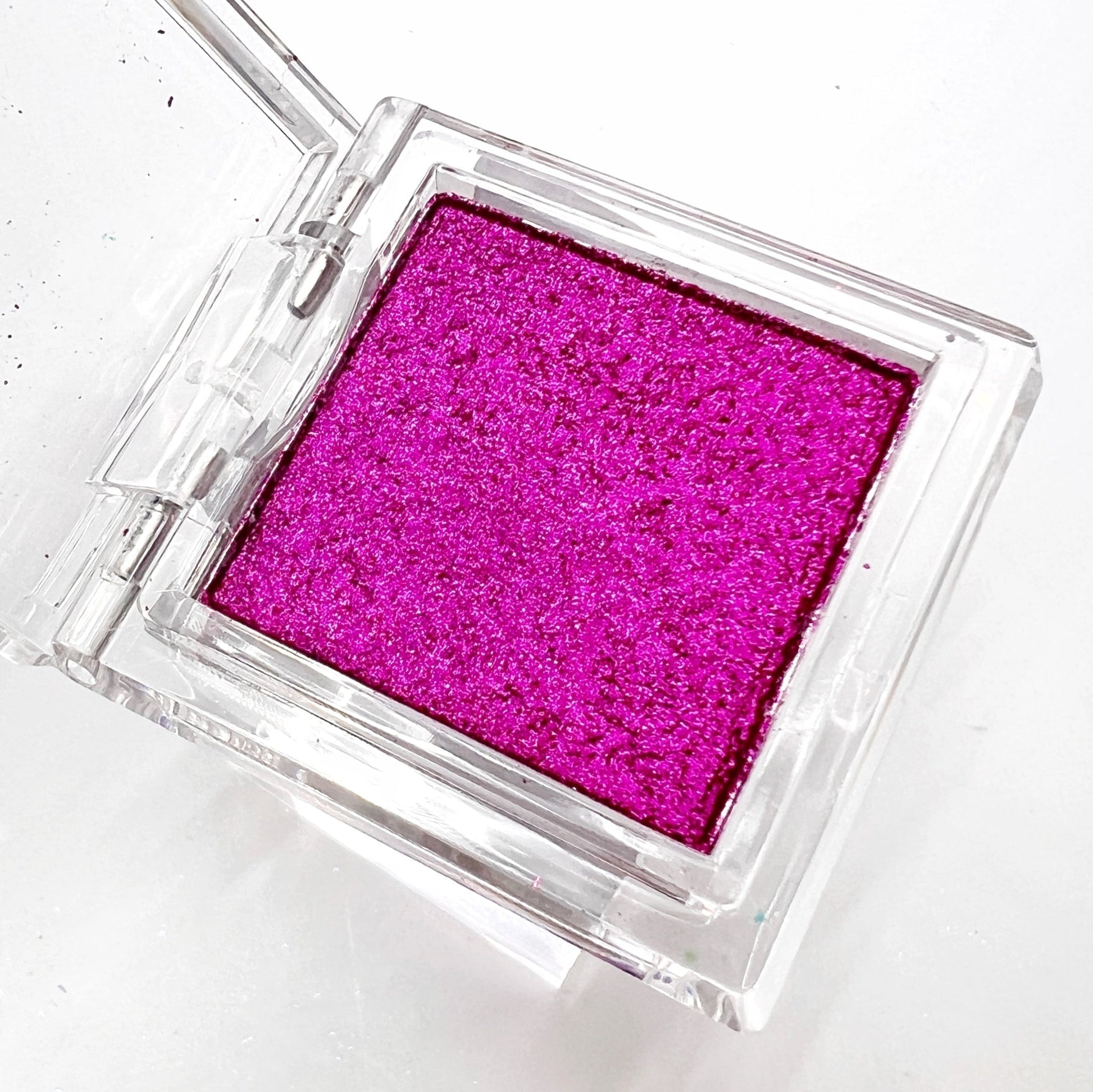 Detail view of  compact with metallic powder on white background. 