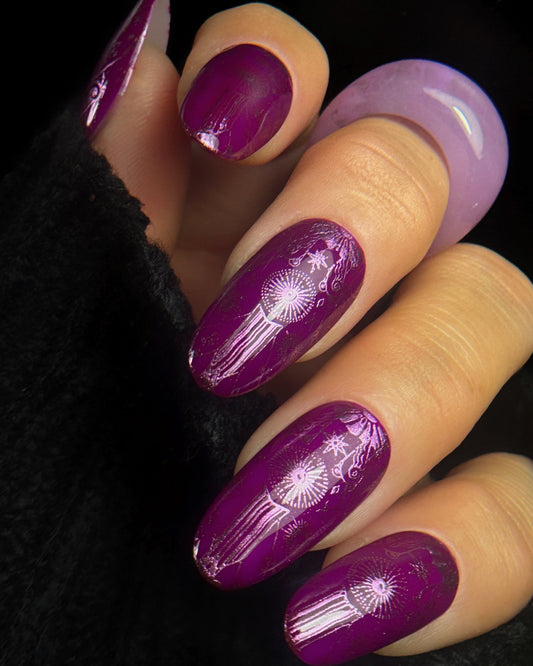 Purple nail polish and cyber violet chrome designs on a black background