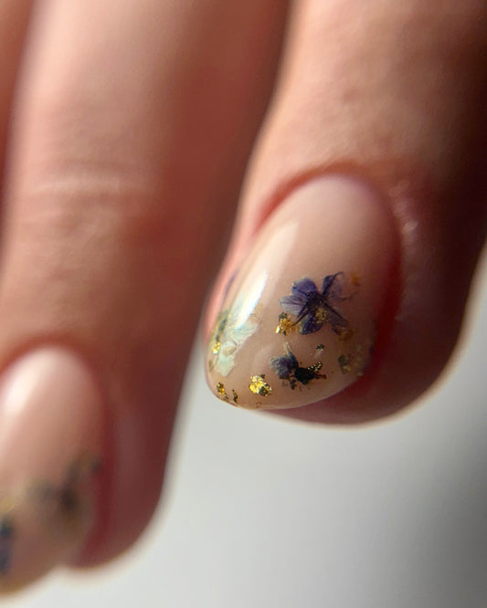 Nail with floral nail art on a neutral background