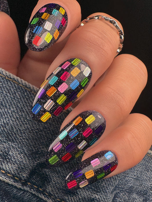 Nails with colorful geometric pattern on a dark background