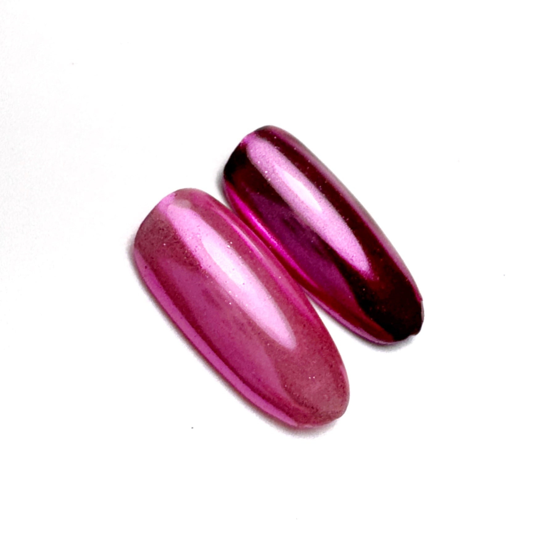 Pink metallic nail tips on white surface