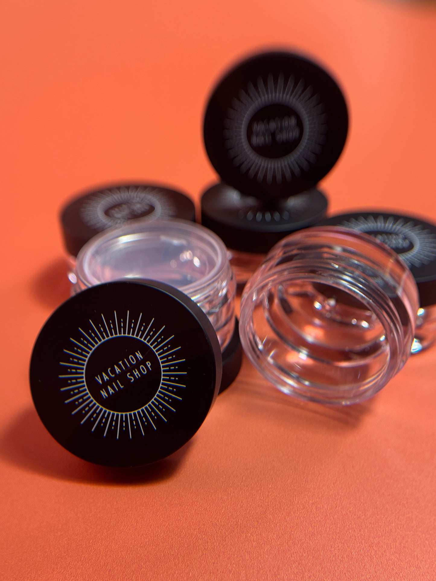 Clear jars with black lids on an orange background