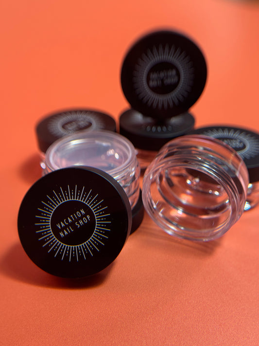 Clear jars with black lids on an orange background