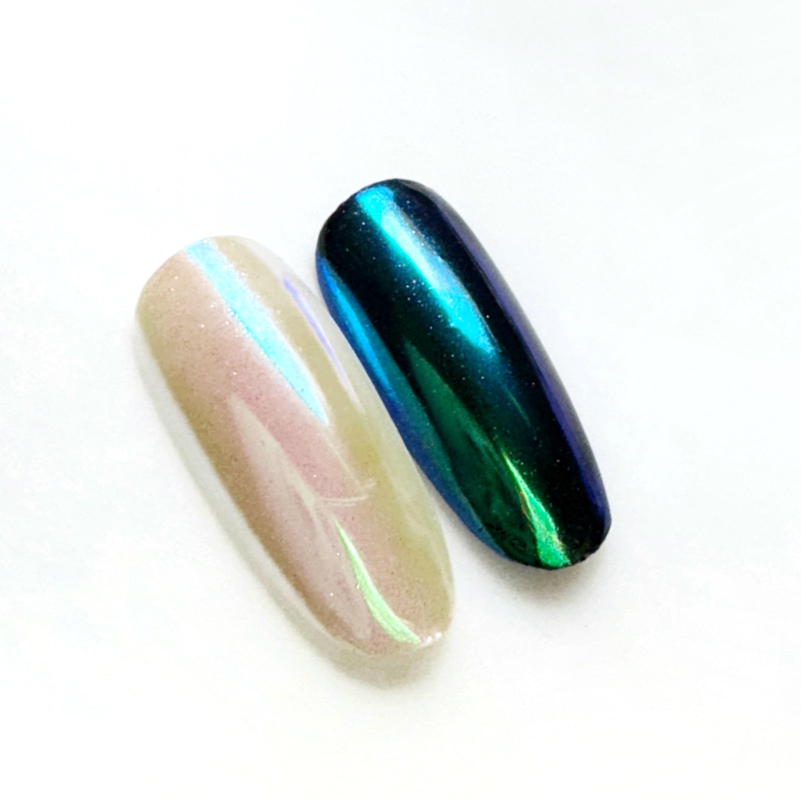 Metallic nail tips on white surface with blurred background.